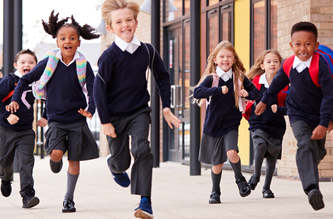 Happy school children running